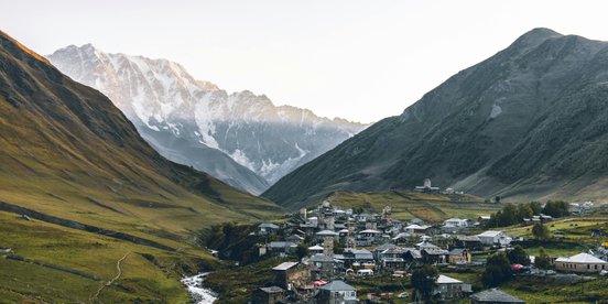kleines Dorf vor Bergkulisse