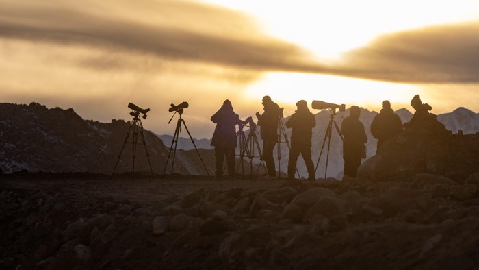 Fotografensilhuetten im Sonnenuntergang vor Bergkulisse