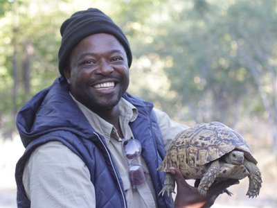 Reiseleiter Rex in Botswana mit einer Schildkröte in der Hand