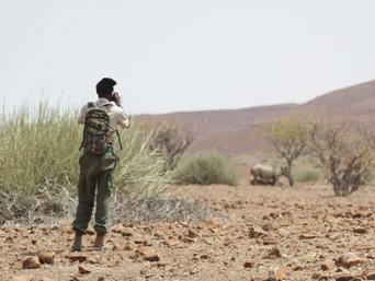 Einheimischer auf Safari beobachtet Nashorn