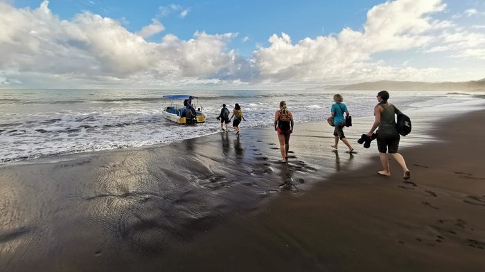 Reisegruppe läuft zu einem Boot am Strand von Corcovado in Costa Rica