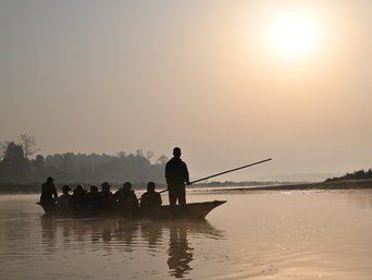 menschen sitzen im kanu und lassen sich einen fluss in nepal herunter treiben