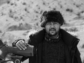 Mann mit Fellmütze schaut in die Kamera