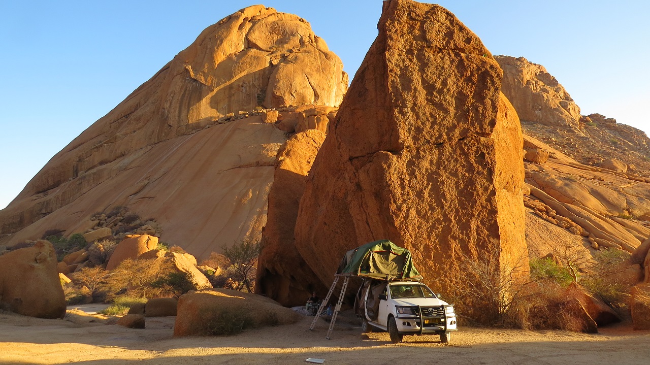 Auto vor einem Felsen in Namibia