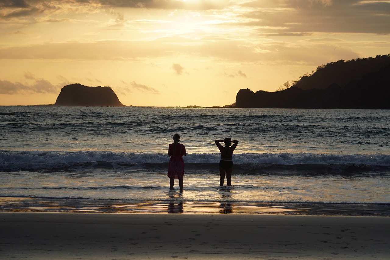 Zwei Frauen am Meer bei Sonnenuntergang