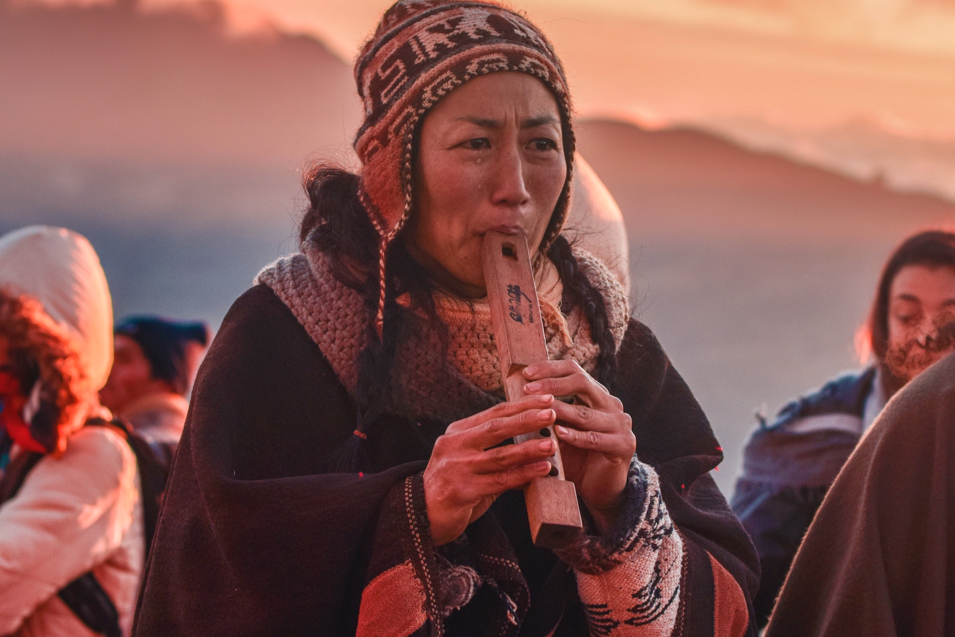 Frau im Sonnenuntergang spielt eine Art Flöte