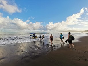 Reisegruppe läuft zu einem Boot am Strand von Corcovado in Costa Rica