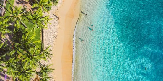 Strand und türkisfarbenes Wasser von oben