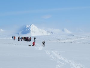 Reisegruppe wandert durch die Schneelandschaft