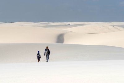 Zwei Menschen wandern in den Dünen der Lagoa Azul Lencois Maranhenses