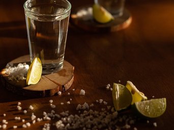 Tequilashots mit Salzkörnern und Limettenstücken