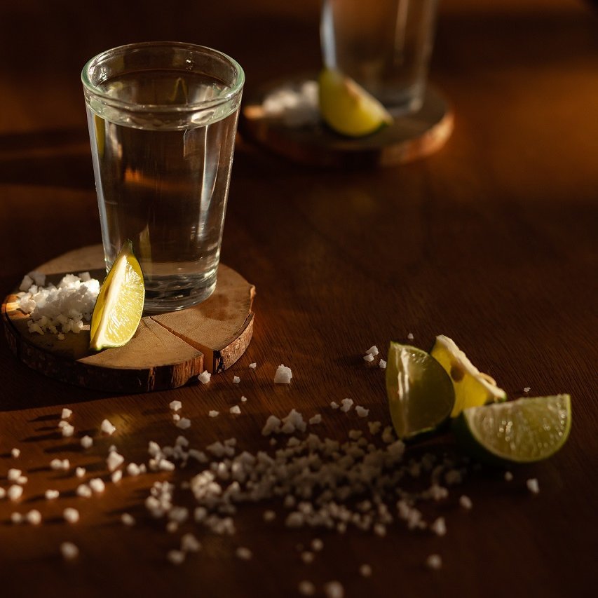 Tequilashots mit Salzkörnern und Limettenstücken