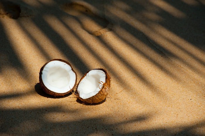 Aufgeschnittene Kokusnuss am Strand
