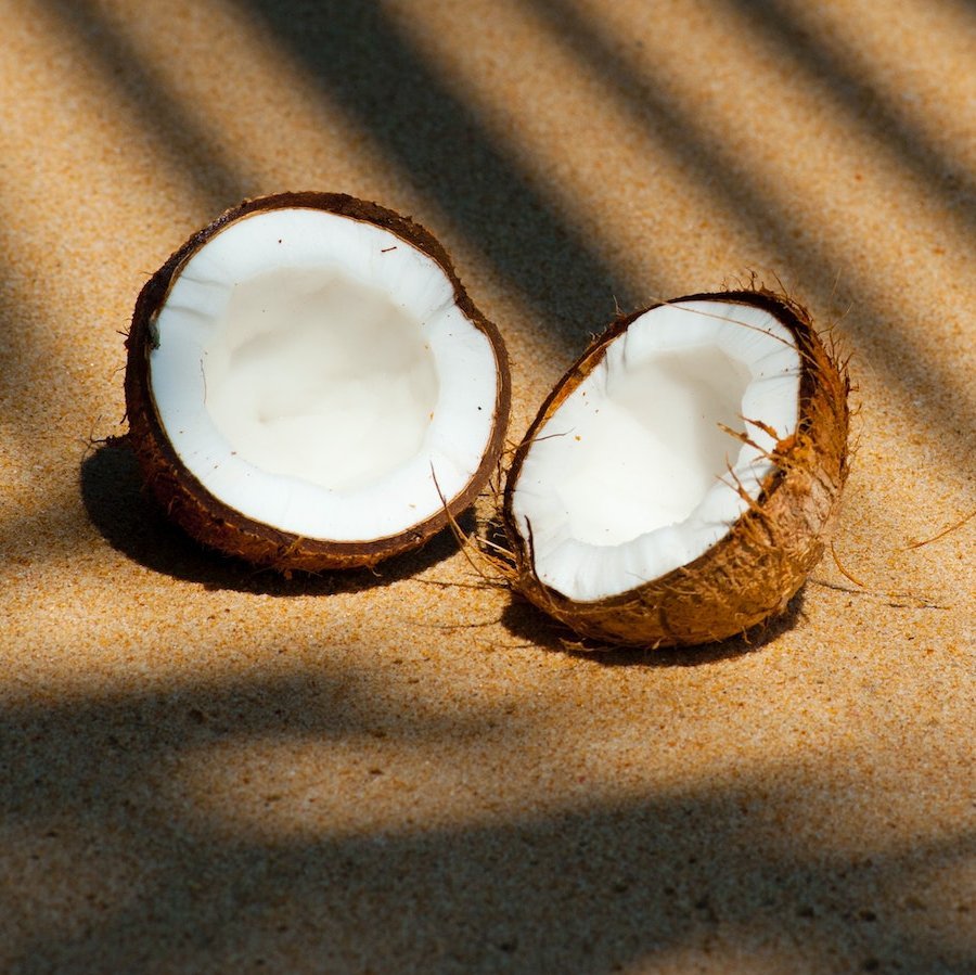 Aufgeschnittene Kokusnuss am Strand