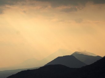 Sonnenuntergang bei regnerischem Wetter über den Bergen