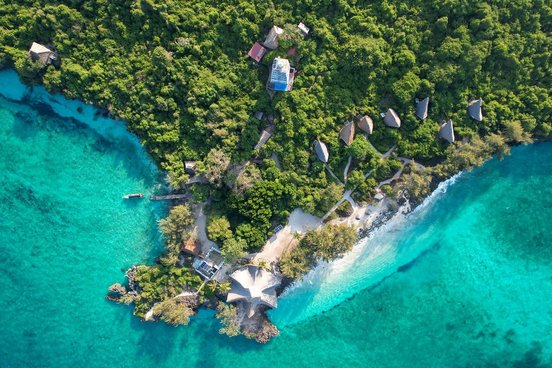 Insel der Chumbe Island Lodge von oben mit türkisfarbenem Meer und kleinen Hütten