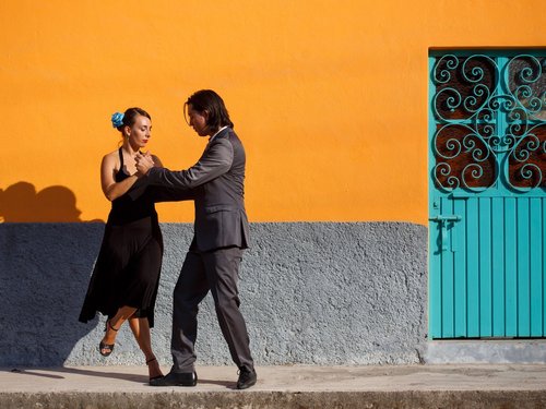 Pärchen beim tanzen vor einer orangenen Wand