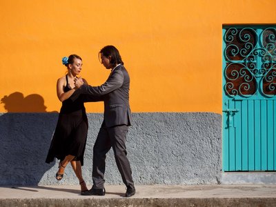 Pärchen beim tanzen vor einer orangenen Wand