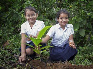 Zwei Schulmädchen aus La Tigra pflanzen einen Baum