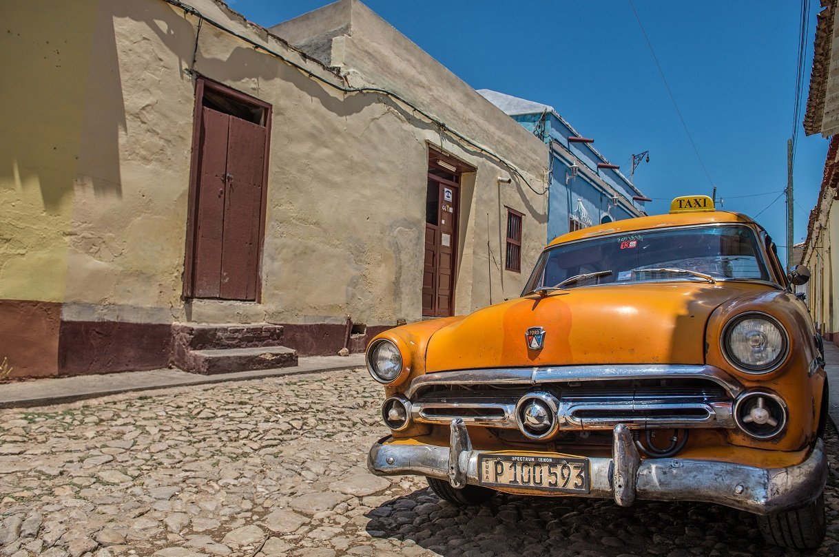 Orangener Oldtimer in einer Gasse in Trinidad