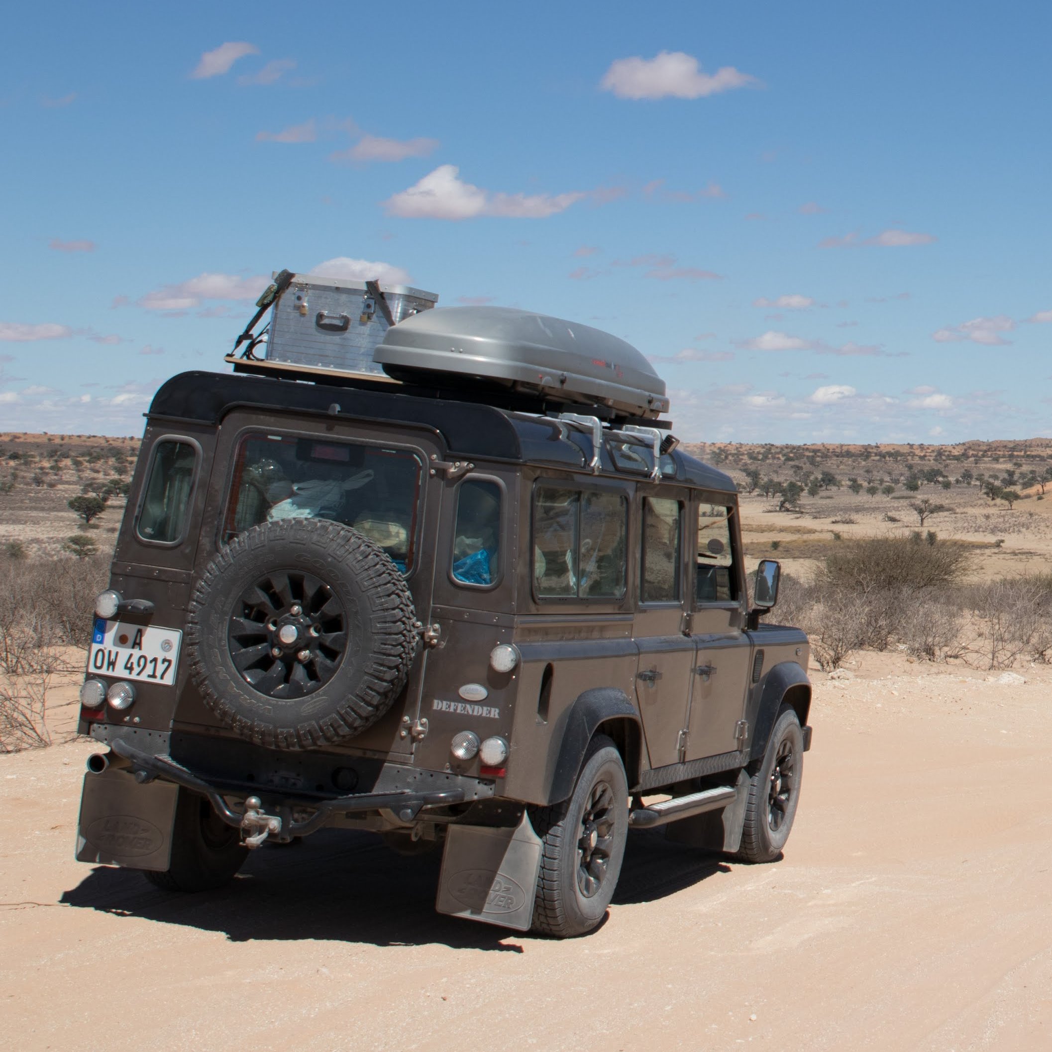 Auto von hinten mit Blick auf die trockene Landschaft Namibias