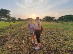 Zwei Menschen in der Savanne vor einem Sonnenuntergang