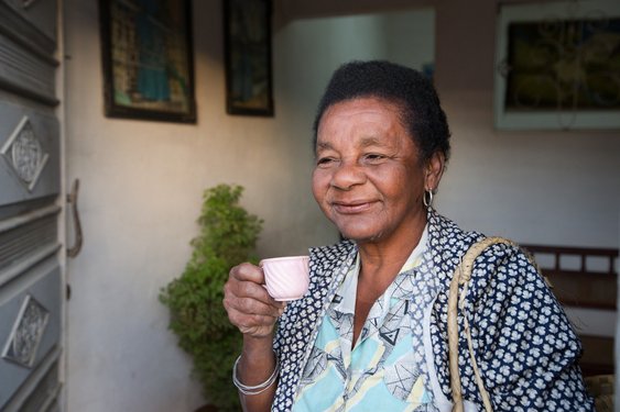 Ältere Frau mit Espressotasse in der Hand lächelt