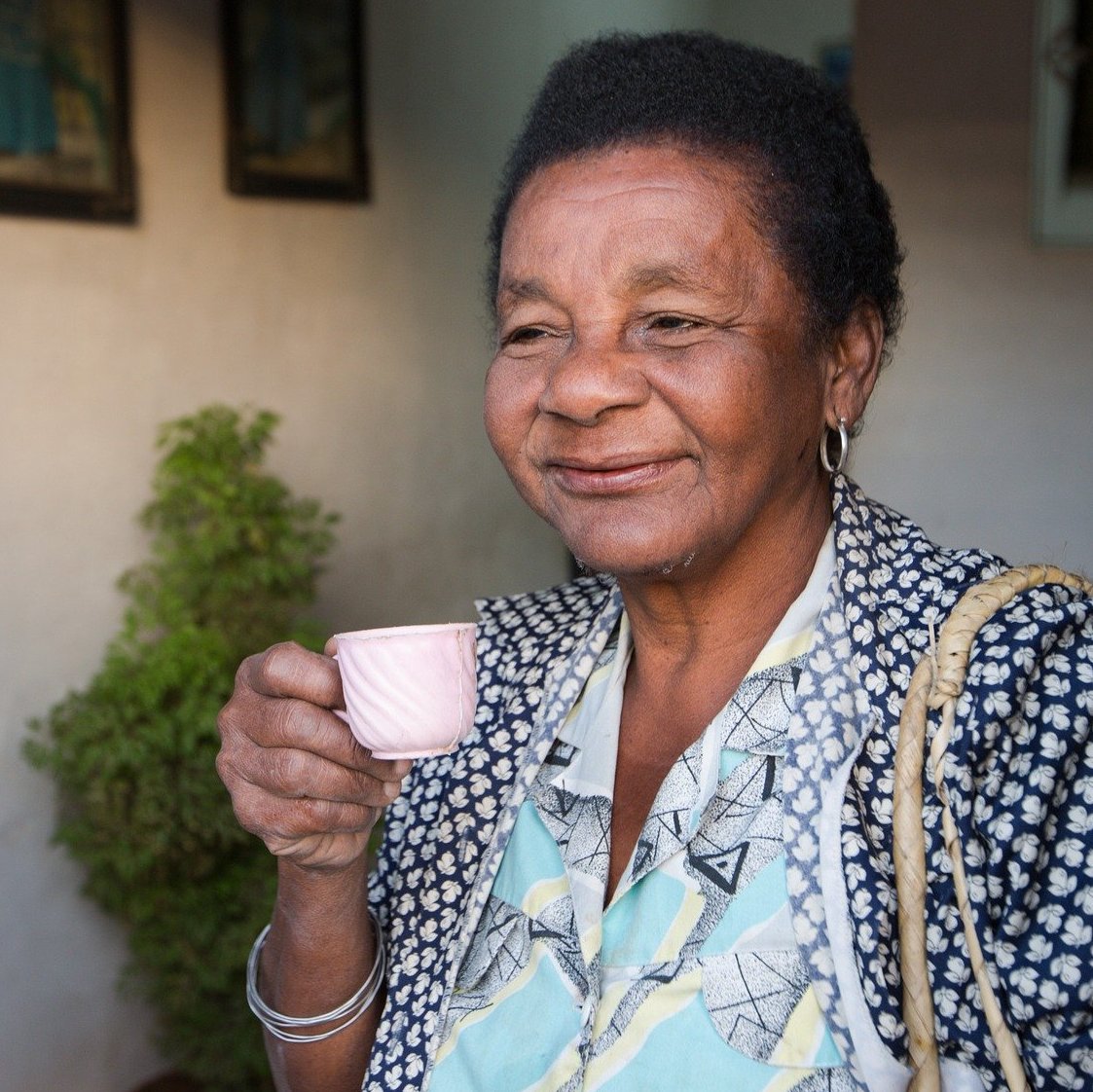 Ältere Frau mit Espressotasse in der Hand lächelt