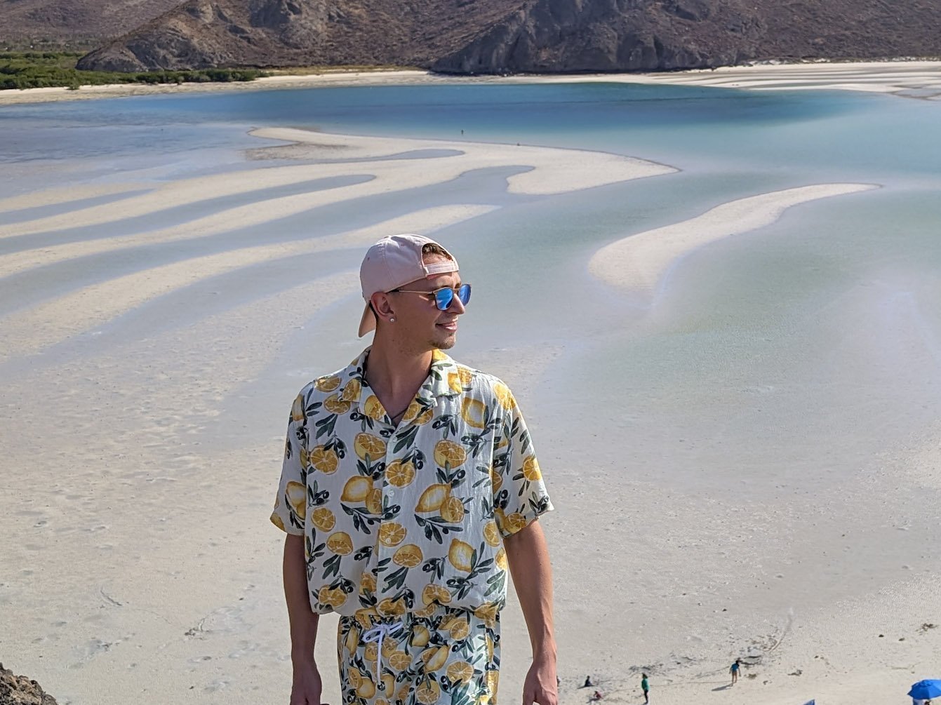 Ein Mann steht auf einer Anhöhe vor dem Playa Balandra und schaut in die Ferne