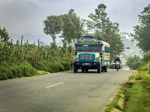 Ein typisch bunter Bus fährt durch ländliche Regionen Guatemalas.