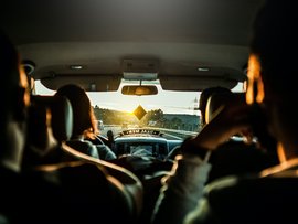 Menschen in einem Fahrzeug bei Sonnenuntergang