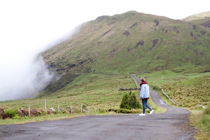 Frau auf einem Wanderweg im Hochland der Azoren