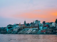 Häuser angestrahlt im Abendlicht am Fluss in Indien