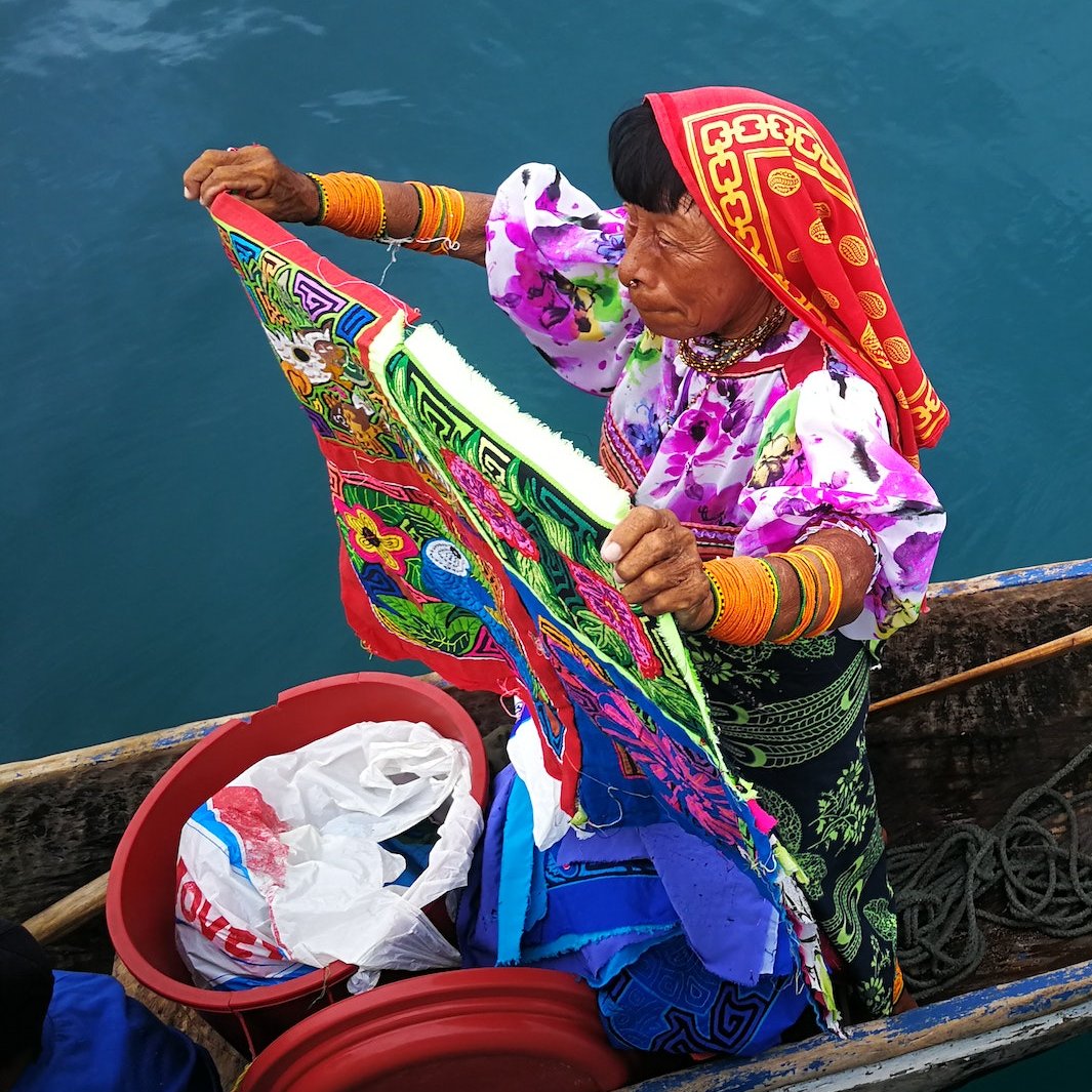 Alte Frau in bunter Kleidung auf einem kleinen Boot