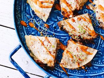 Quesadilla auf einem blauen Teller angerichtet