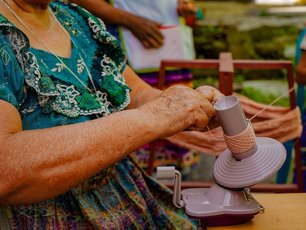 Ausschnitt von Händen die Garn auf eine Spule wickeln