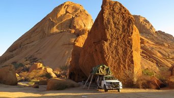 Auto vor einem Felsen in Namibia