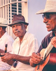 Drei Musiker auf einer Bank in Kuba
