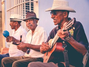 Drei Musiker auf einer Bank in Kuba