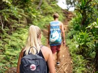 Zwei Menschen laufen im Dschungel für ein Trekking