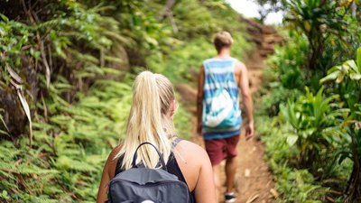 Zwei Menschen laufen im Dschungel für ein Trekking