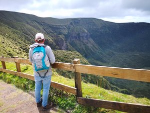 Mann mit travel-to-nature Rucksack genießt die Aussciht auf den Krater von Caldeira do Faial