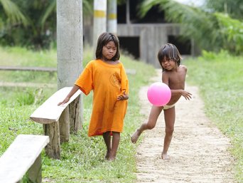 Zwei Kinder aus Kolumbien spielen mit einem rosa Luftballon