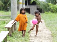 Zwei Kinder aus Kolumbien spielen mit einem rosa Luftballon