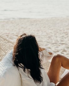 Frau in Hängematte entspannt am Strand