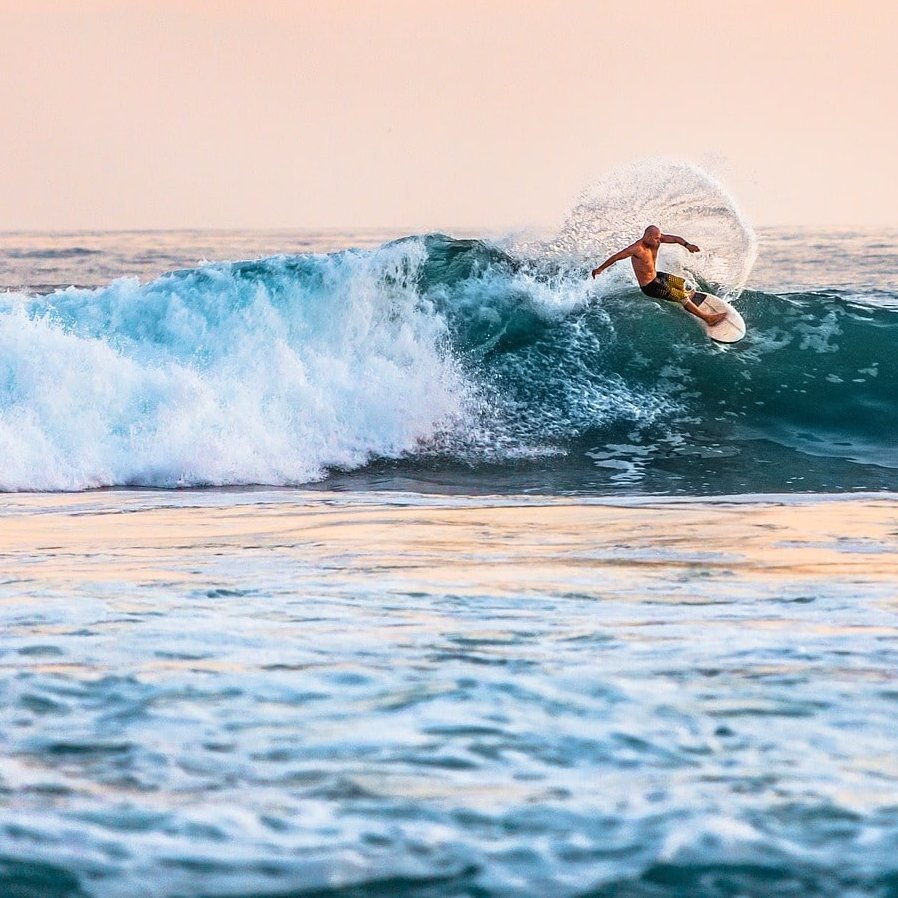 Ein Surfer surft auf einer Welle im Meer