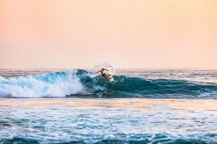 Ein Surfer surft auf einer Welle im Meer