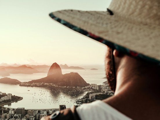 Mann mit Hut schaut auf den Christus Statue bei Sonnenuntergang