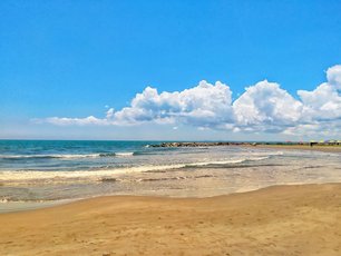 Gelber Sand, blaues Wasser und strahlender Himmel