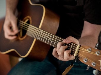 Mensch spielt Gitarre